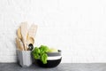 Kitchen tools, olive cutting boan a kitchen shelf against a white brick wall. Fresh basil and lemon. White and black Royalty Free Stock Photo
