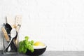 Kitchen tools, olive cutting boan a kitchen shelf against a white brick wall. Fresh basil and lemon. White and black Royalty Free Stock Photo