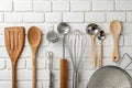 Kitchen tools, utensils, and kitchenware on white brick wall Royalty Free Stock Photo