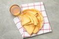 Kitchen towel with plate of thin pancakes and tea on gray table Royalty Free Stock Photo