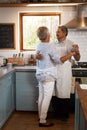 The kitchen is the unofficial dance floor. a happy mature couple dancing together while cooking in the kitchen at home. Royalty Free Stock Photo