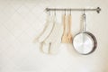 Kitchen utensil Glove and Pan Wooden Spoon on Tiles wall