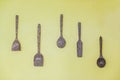 Kitchen utensil: wooden spoon, wooden fork and wooden spatula hang on green wall Royalty Free Stock Photo