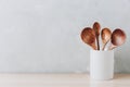 Kitchen utensils background. Wooden spoons in a white jug on light background with copy space Royalty Free Stock Photo