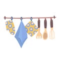 Kitchen utensils and dish towel hanging on a rack. Wooden spoons, whisk, and patterned towel. Home cooking and kitchen Royalty Free Stock Photo