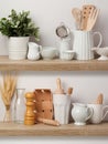 Kitchen utensils and dishware on wooden shelf. Royalty Free Stock Photo