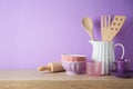 Kitchen utensils and dishware on wooden shelf. Kitchen interior purple background Royalty Free Stock Photo