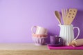 Kitchen utensils and dishware on wooden shelf. Kitchen interior purple background Royalty Free Stock Photo