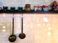 Utensils hanging on the kitchen of a restaurant next to a shelf with spices Royalty Free Stock Photo