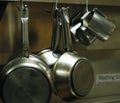 Kitchen utensils, pans and pots hanging with hooks Royalty Free Stock Photo