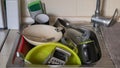 The kitchen utensils in the wash basin need to be washed. A pile of dirty dishes in the kitchen sink. Kitchen utensils need Royalty Free Stock Photo