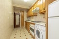 Kitchen with vintage pine wood furniture with drawers and bottle racks, white appliances