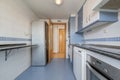 kitchen with white and blue furniture, built-in appliances, drawers and column Royalty Free Stock Photo