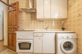 Kitchen with white cabinets and appliances in the same color and small square yellow tiles