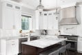 A kitchen with white cabinets, wood island, and stainless steel appliances. Royalty Free Stock Photo