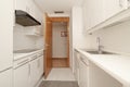 Kitchen with white furniture with drawers, floors, walls and ceilings of the same color and pear-colored wooden access door