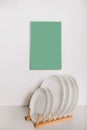 Kitchen white plates on a wooden stand on a background of mint mocap. Kitchen interior design concept Royalty Free Stock Photo
