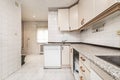 kitchen with white tiles with L-shaped furniture