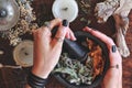 Kitchen witchery - female wiccan witch holding pestle and mortar in her hands, making magickal herb blend for a spell Royalty Free Stock Photo