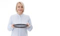 Kitchen woman gives empty black plate for your advertising products isolated on white background. Mock up for use