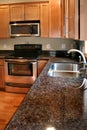 Kitchen wood cabinets black and stainless stove Royalty Free Stock Photo