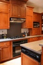 Kitchen wood cabinets black and stainless stove Royalty Free Stock Photo