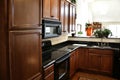Kitchen wood cabinets black and stainless stove Royalty Free Stock Photo