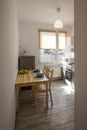 Real and special, small kitchen equipped with a table, chairs and fridge.