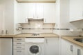 Kitchenette with light wood countertops and white cabinets