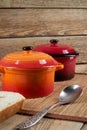 Kitchenware. Colored ceramic saucepans on wooden background