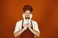 Kitchenware and cooking concept. Chef with excited face holds wooden spoon and spatula Royalty Free Stock Photo