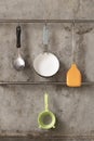 Kitchenware hanging on stainless rail on cement wall background