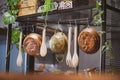 Kitchenware. A vintage photo of kitchen tools hanging in the kitchen including wooden ladle, wooden salad servers Royalty Free Stock Photo