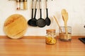 Kitchenware with wooden spoons in vase on wooden table