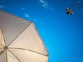 Kite blue sky. Colorful high flying toy. Air kite fly on wind clouds. Rainbow kite in summer background. Concept of Royalty Free Stock Photo