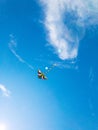 Kite blue sky. Colorful high flying toy. Air kite fly on wind clouds. Rainbow kite in summer background. Concept of