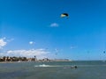 Kite boarding sportsman flying high with kite and kiteboard in boots in the blue sky, active sports and life style in spanish Royalty Free Stock Photo