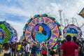 kite in circular shape drawing of painted woman, with people walking