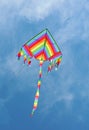 Kite with the colors of the rainbow flies in the sky Royalty Free Stock Photo