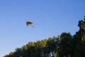 A kite flies across the blue sky with LGBT rainbow colors Royalty Free Stock Photo