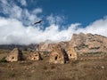 A kite flies over a grave crypt. Old stone tomb, a crypt on the top of a mountain. Old Ossetian family crypt in the misty