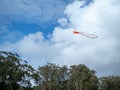 Kite flying high in the sky with parting clouds Royalty Free Stock Photo