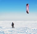 Kite surfer being pulled by his kite across the snow Royalty Free Stock Photo