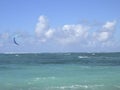 Kite surfer on blue water, with blue kite high in the air, and blue sky in background Royalty Free Stock Photo