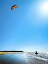 Kite Surfer walking out the sea against a beautiful blue sky. Silhouette of kite surfer in the beach Royalty Free Stock Photo