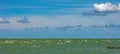 Kite-surfer, on a wavy sea surface, with wind turbines in the background, the concept of wind power Royalty Free Stock Photo