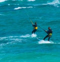 Two kite surfers riding waves