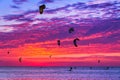 Kite-surfing against a beautiful sunset. Many silhouettes of kit Royalty Free Stock Photo