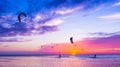 Kite-surfing against a beautiful sunset. Many silhouettes of kit