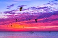 Kite-surfing against a beautiful sunset. Many silhouettes of kit Royalty Free Stock Photo